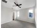 Large main bedroom with grey carpet, ceiling fan and two windows at 1162 Atlantic Ave, Fruitland Park, FL 34731
