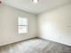 Well-lit bedroom featuring a large window and gray carpet at 13566 Sw 79Th Terrace Rd, Ocala, FL 34473