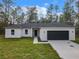 Single-story home with a two-car garage and a large front yard at 13566 Sw 79Th Terrace Rd, Ocala, FL 34473