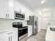 Modern kitchen with white cabinets and stainless steel appliances at 13566 Sw 79Th Terrace Rd, Ocala, FL 34473