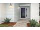 Modern black front door with updated light fixtures and walkway at 1633 Cedar Glen Dr, Apopka, FL 32712