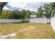 Large backyard enclosed with a white vinyl fence and mature trees at 2002 Geigel Ave, Orlando, FL 32806