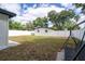 Spacious backyard with white fence, mature trees, and a charming swing set at 2002 Geigel Ave, Orlando, FL 32806