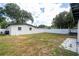 Large fenced yard with mature trees and a patio area, ideal for outdoor entertaining at 2002 Geigel Ave, Orlando, FL 32806