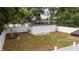 A view of a grass and dirt backyard with a storage shed, enclosed by a white wooden fence at 2002 Geigel Ave, Orlando, FL 32806