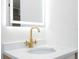 Bathroom sink with gold faucet and backlit mirror at 2002 Geigel Ave, Orlando, FL 32806