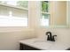 Bathroom closeup on the vanity with mirror and a view of the exterior through the window at 2002 Geigel Ave, Orlando, FL 32806
