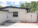 Charming home featuring a white exterior, dark roof, and well-maintained landscaping and gated entry at 2002 Geigel Ave, Orlando, FL 32806