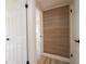 An image that shows a view of a hallway looking into another room with wood-look flooring and white doors at 2002 Geigel Ave, Orlando, FL 32806
