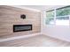 Living room featuring wood-look accent wall with a fireplace and a large window at 2002 Geigel Ave, Orlando, FL 32806