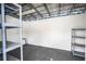 Empty shed interior with dark floor and overhead shelving for storage at 2002 Geigel Ave, Orlando, FL 32806