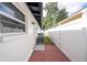 Red brick walkway between the home and vinyl fence, with window and AC unit visible at 2002 Geigel Ave, Orlando, FL 32806