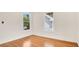 Bright bedroom featuring hardwood floors and dual windows showcasing lush tree views at 219 Laurel Ave, Sanford, FL 32771