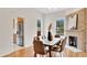 Bright dining room features a brick fireplace, wood floors, a modern table, and an adjacent kitchen at 219 Laurel Ave, Sanford, FL 32771