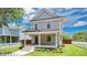 Charming two-story home with a covered front porch and beautiful landscaping on a well-maintained lawn at 219 Laurel Ave, Sanford, FL 32771