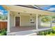 Inviting front porch with classic columns and dark wood door with a view of the yard at 219 Laurel Ave, Sanford, FL 32771