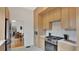 Contemporary kitchen with stainless steel appliances, light wood cabinets, and a view into the dining room at 219 Laurel Ave, Sanford, FL 32771