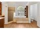 Bright bathroom featuring a soaking tub with views, a walk-in shower, and a separate toilet room at 278 Eaglet Way, Lake Mary, FL 32746