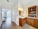 Bathroom with wood-look tile floors, wood cabinets, granite countertop, open shelving, and view to main bedroom at 278 Eaglet Way, Lake Mary, FL 32746