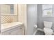 Modern bathroom with a white vanity, decorative mirror, and toilet at 278 Eaglet Way, Lake Mary, FL 32746