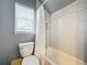 Cozy bathroom featuring a tiled tub and shower, toilet, and window with natural light at 278 Eaglet Way, Lake Mary, FL 32746