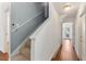 Hallway with stairs featuring carpet and wood floors, grey and white walls, and bright lighting at 278 Eaglet Way, Lake Mary, FL 32746