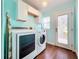 Bright laundry room with washer, dryer, cabinets, and backyard access at 278 Eaglet Way, Lake Mary, FL 32746