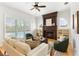 Bright living room featuring a cozy fireplace, plush seating, and views of the outdoor pool at 278 Eaglet Way, Lake Mary, FL 32746