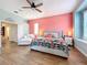 Main bedroom with wood-look floors, coral walls, and a comfortable seating area at 278 Eaglet Way, Lake Mary, FL 32746
