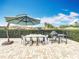 Inviting outdoor dining area with a large table, umbrella, grill, and well-manicured landscaping at 278 Eaglet Way, Lake Mary, FL 32746