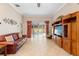 Bright living room with tile floors, leather sofa, and built-in entertainment center at 3413 Foxcroft Cir, Oviedo, FL 32765