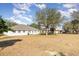 Large backyard featuring a white home and mature trees at 36502 Barrington Dr, Eustis, FL 32736