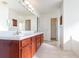 Bright bathroom featuring a double sink vanity with granite counters and wood cabinets at 36502 Barrington Dr, Eustis, FL 32736