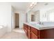 Bright bathroom featuring a double sink vanity with granite counters and wood cabinets at 36502 Barrington Dr, Eustis, FL 32736