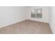 Neutral carpeted bedroom featuring a window with natural light at 36502 Barrington Dr, Eustis, FL 32736