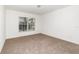Neutral carpeted bedroom featuring a window with natural light and white walls at 36502 Barrington Dr, Eustis, FL 32736