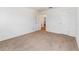 Neutral carpeted bedroom with white walls and an open entry door at 36502 Barrington Dr, Eustis, FL 32736