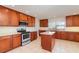 Bright kitchen with stainless steel appliances, island, tile floors, and granite countertops at 36502 Barrington Dr, Eustis, FL 32736