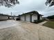 Three-car garage with white brick exterior and a long driveway at 4010 Winderlakes Dr, Orlando, FL 32835