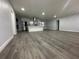 Spacious living room with gray vinyl plank flooring and a modern kitchen at 4010 Winderlakes Dr, Orlando, FL 32835