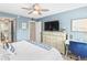 Bright bedroom with king bed, dresser, and TV at 4175 S Atlantic Ave # 4070, New Smyrna Beach, FL 32169