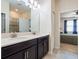 Double vanity bathroom with dark cabinets, quartz countertops, and an open shower at 4567 Tribute Trl, Kissimmee, FL 34746
