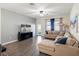 Living room features a sectional sofa, wood-look floors, and access to the backyard at 4567 Tribute Trl, Kissimmee, FL 34746