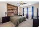 Main bedroom with wood accent wall, ceiling fan, and dark wood nightstands at 4567 Tribute Trl, Kissimmee, FL 34746