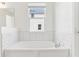 Bright bathroom featuring a large soaking tub with white tile surround and window at 5000 Northern Dove Ave, Mount Dora, FL 32757