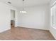 Elegant dining room with wood-look tile floors and a stylish chandelier, perfect for gatherings at 5000 Northern Dove Ave, Mount Dora, FL 32757