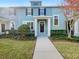Two-story house with teal exterior, walkway, and landscaping at 510 Rainbow Springs Loop, Groveland, FL 34736