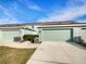 Attached garage with light teal exterior and AC units at 510 Rainbow Springs Loop, Groveland, FL 34736