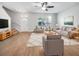 Bright living room features hardwood floors, comfy seating, and large windows at 510 Rainbow Springs Loop, Groveland, FL 34736