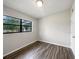 Simple bedroom with wood-look floors and a large window at 6117 Oakcrest Cir, Orlando, FL 32808